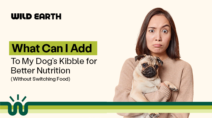 A woman in a beige shirt holding a pug