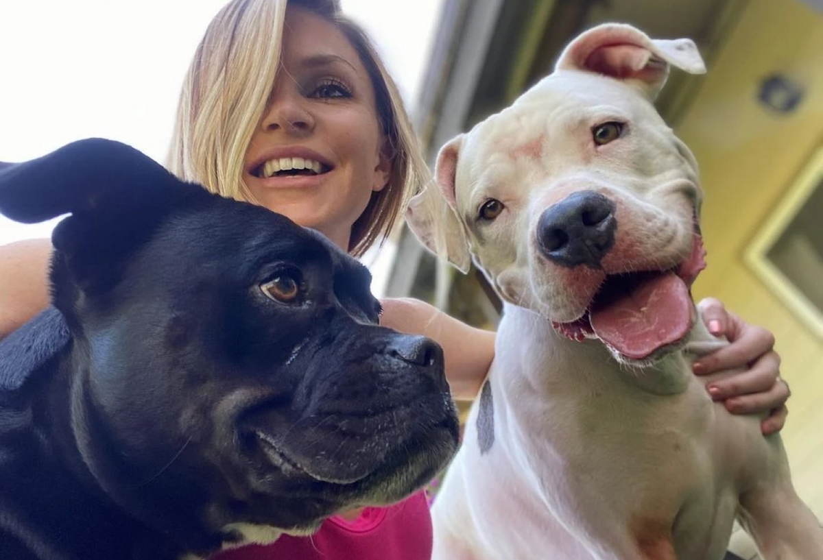 A woman smiling with two dogs.